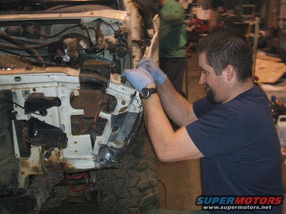 White 1992 Ford Bronco front end being worked on, showing exposed engine components and rusty frame