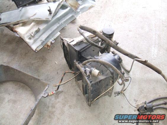 Disassembled vehicle AC evaporator and condenser unit with hoses and wiring