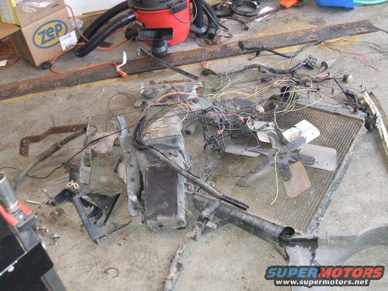 Radiator, fan, AC condenser, and wiring harness disassembled on the floor