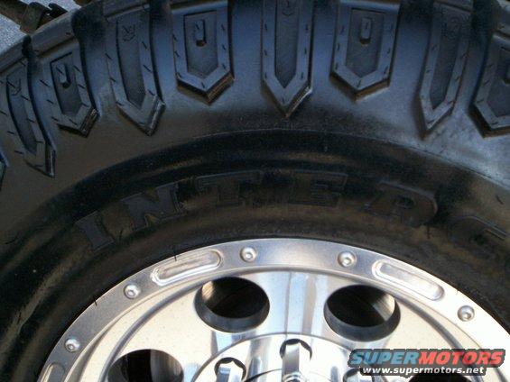 Close-up of a large tire with 'INTER' visible on the sidewall and a chrome wheel