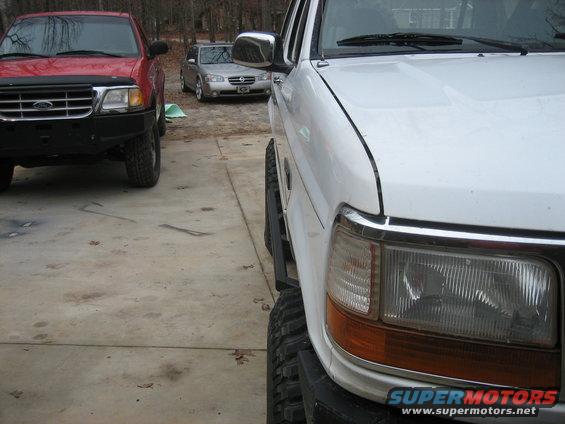 White 1996 Ford Bronco with aftermarket sliders and large tires
