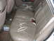 1993 Ford Taurus - Interior view of worn tan leather rear car seats with visible damage and seatbelts.
