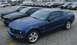 2003 Ford Crown Victoria - A blue Ford Mustang GT is parked in a lot with several other vehicles visible in the background.