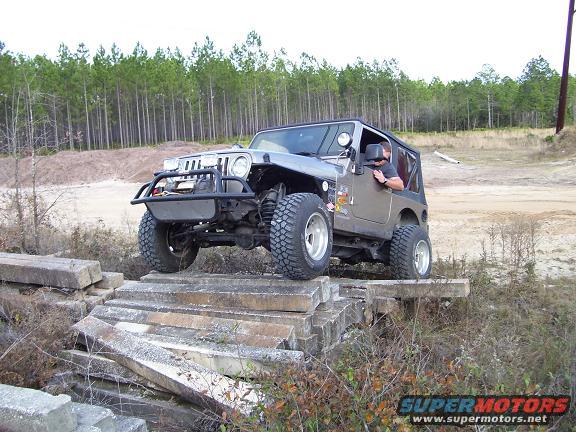 Gray Jeep Wrangler TJ driving over concrete obstacles