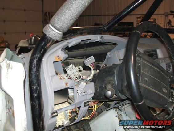 dashboard of a vehicle with wiring exposed, roll cage installed