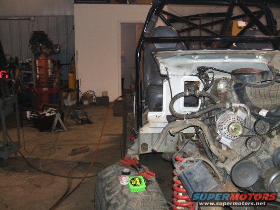 Vehicle front end disassembled, engine exposed, in a workshop