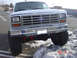 1983 Ford Bronco - Lifted 1980s Ford pickup truck with large tires parked in a snowy lot.
