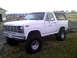 1983 Ford Bronco - This lifted 1980 Ford Bronco features a prominent grille and large off-road tires, captured in a three-quarter front view.