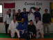 1984 Ford Bronco - A group of martial artists, some in gis and some in casual wear, pose for a photo in a dojo with a dragon mural and school name on the wall.