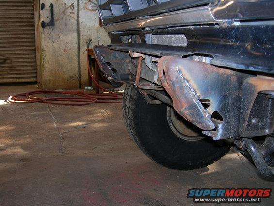 Modified front bumper mounts on a vehicle, showing custom welding and rust