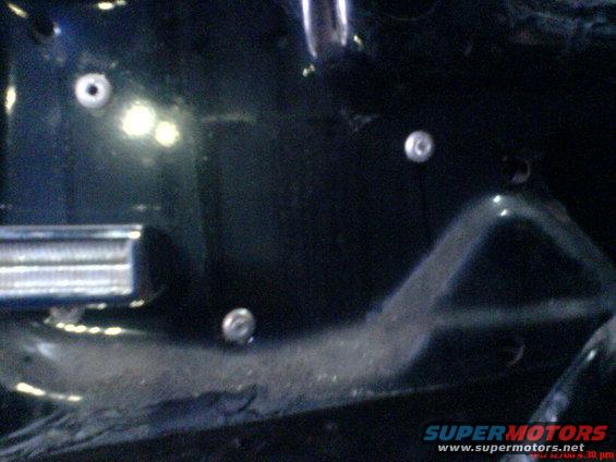 Interior door panel with visible screw holes and a metal trim piece