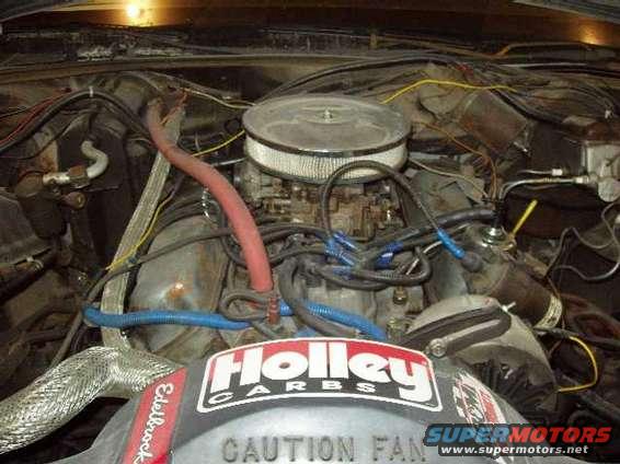 engine bay with Holley carburetor and air cleaner, some wiring and hoses visible