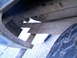 1987 Ford Bronco II - Close-up view of a vehicle's undercarriage, showing structural components and a tire.