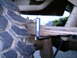 1987 Ford Bronco II - A measurement tool is attached to the leaf spring of a vehicle, near the tire.