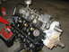 1979 Ford F-150 - A V8 engine, likely from a truck, is mounted on an engine stand for repair or rebuilding.