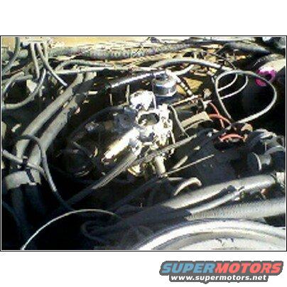 Engine bay showing carburetor, hoses, and wiring
