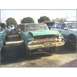 1972 Ford Ranchero - A weathered green vehicle sits in a lot filled with other cars, showing significant front-end damage.