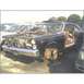 1972 Ford Ranchero - This car is in a junkyard, missing its hood and front wheels, with its doors open.