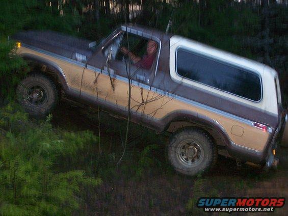 Brown and tan 1978 Ford Bronco off-roading on a dirt trail