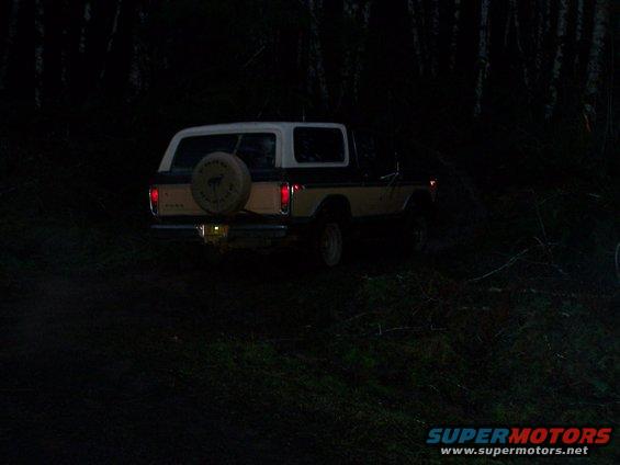 1978 Ford Bronco with a spare tire on the back, parked off-road at dusk