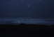 1993 Ford Bronco - A dark, hazy scene of ocean waves under a dim sky, with several bright circular lights visible.