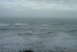 1993 Ford Bronco - The vast ocean stretches out under a cloudy sky, with waves crashing on the shore.