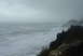 1993 Ford Bronco - Stormy ocean waves batter a coastline with a cloudy sky overhead.