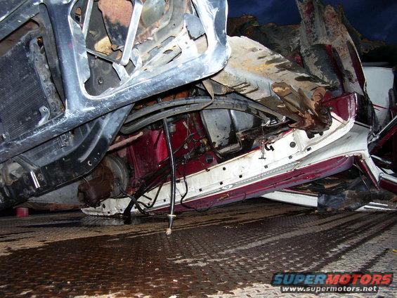 Damaged vehicle frame and engine components, appears to be a total loss