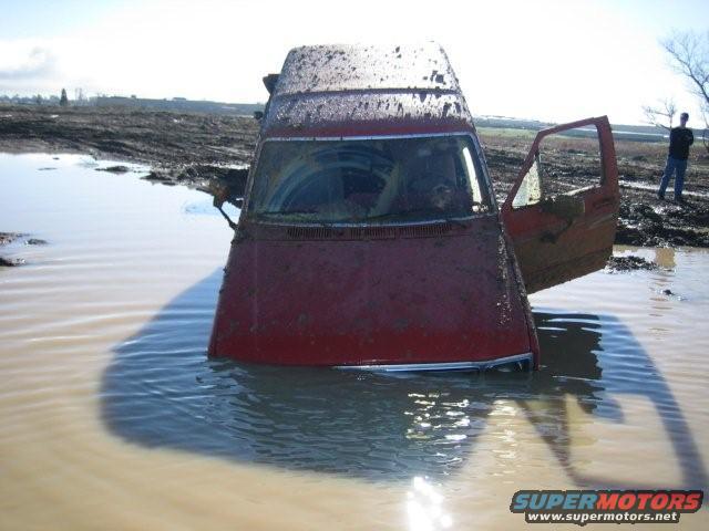 1986 Ford Bronco stuck in mud with driver's door open