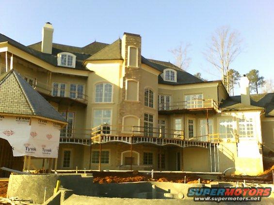 Large house under construction with scaffolding and Tyvek wrap visible