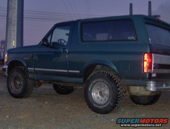 1996 Ford Bronco, dark green, side view with aftermarket wheels and tires