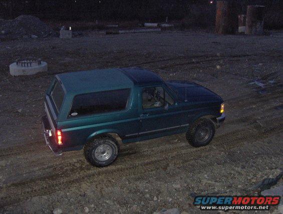 Green 1996 Ford Bronco parked on dirt at dusk