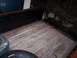 1979 Chevrolet C/K Pickup - The interior of a truck bed shows weathered wooden planks and metal strips, with two spare tires present.