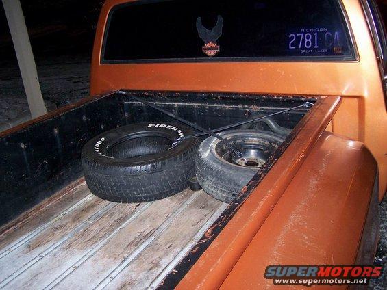 Orange 1979 Chevrolet C/K Pickup rear bed with two tires and Michigan license plate