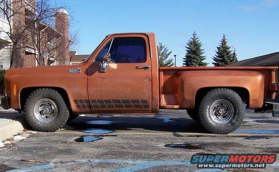Side view of an orange 1979 Chevrolet C/K Pickup truck with aftermarket wheels