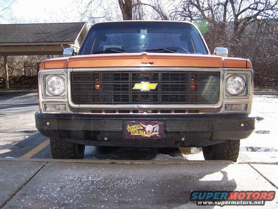 Orange Chevrolet C/K Pickup front view, showing grille and bumper with a "Broken Spirit" license plate