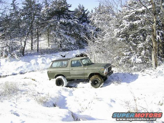 1978 Ford Bronco driving through snow-covered trees