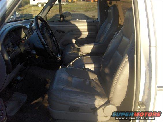 Interior of a 1995 Ford Bronco, showing gray leather seats, dashboard, and steering wheel