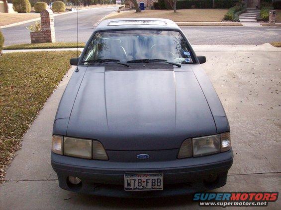 Front view of a gray 1989 Ford Mustang parked in a driveway