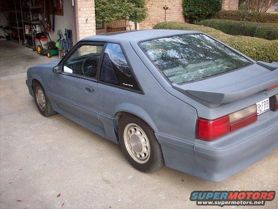 Gray 1989 Ford Mustang coupe with a spoiler and a primer finish