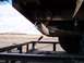 1995 Ford Bronco - The underside of a vehicle, including its exhaust pipe and trailer hitch, is visible while on a trailer.
