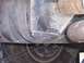 1995 Ford Bronco - Close-up view of a vehicle's undercarriage, revealing mechanical components and a tire.