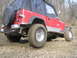 2002 Ford Sport Trac - This red Jeep Wrangler navigates a muddy off-road trail, its capabilities.