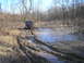 2002 Ford Sport Trac - Jeep Wrangler off-roading through a muddy, wooded area.