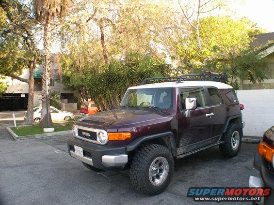 Dark purple 2007 Toyota FJ Cruiser with white roof and roof rack parked on asphalt