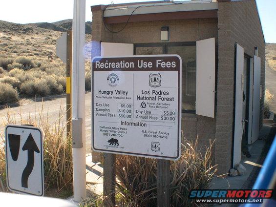 Fee station with signs for Hungry Valley and Los Padres National Forest. A road sign is visible to the left