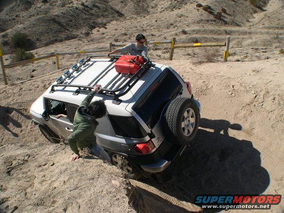 White 2007 Toyota FJ Cruiser stuck off-road with two people trying to free it