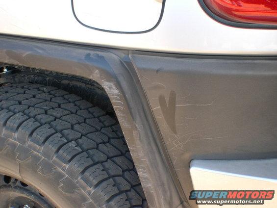 2007 Toyota FJ Cruiser rear fender and tire with visible scratches on the plastic trim