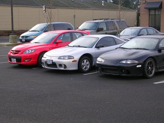Red 2007 Mazda 3 hatchback parked in a lot with other cars