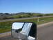 1988 Ford Bronco - Reflection in side mirror shows a truck on the highway, with a scenic landscape beyond.
